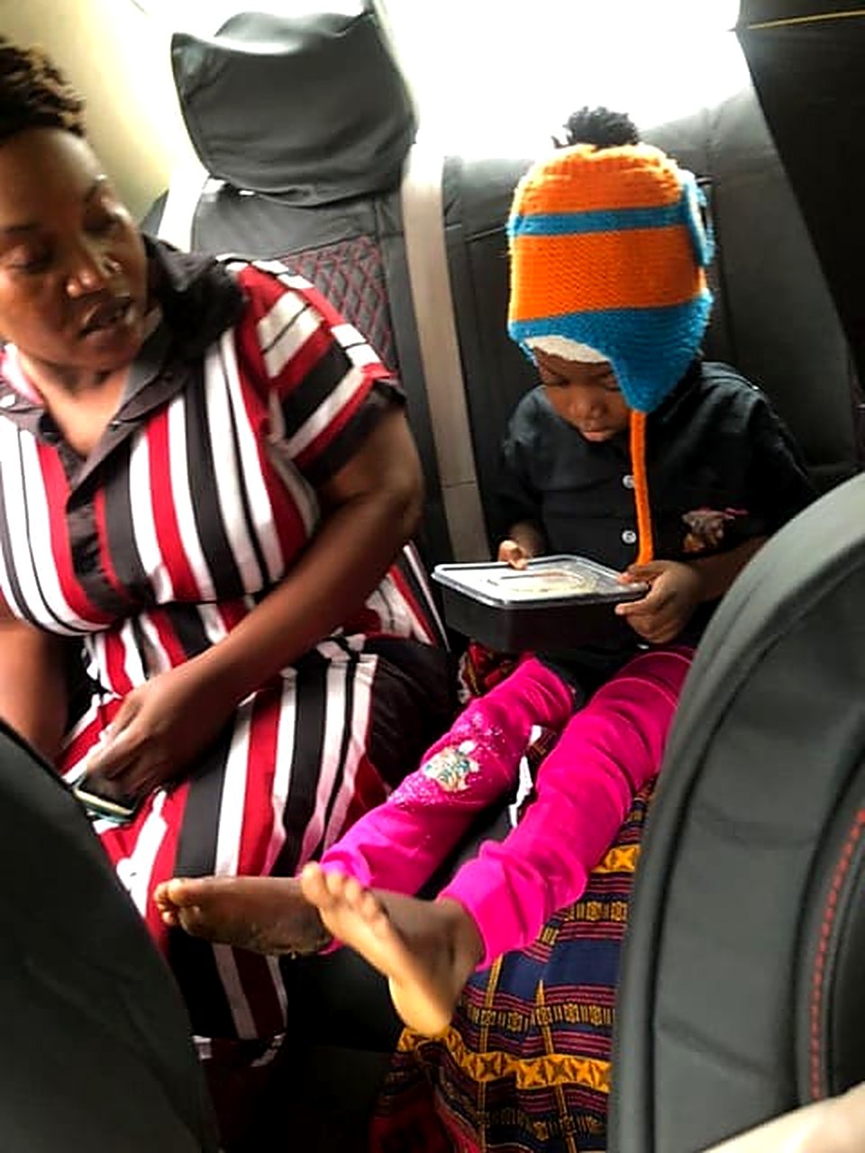 Success in a knit hat, sitting beside a caregiver